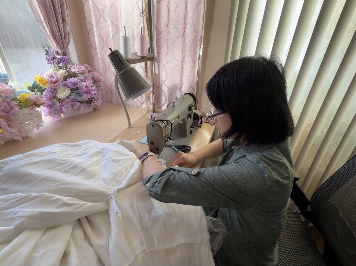 Elaine hand-sewing a wedding gown in her Sacramento studio